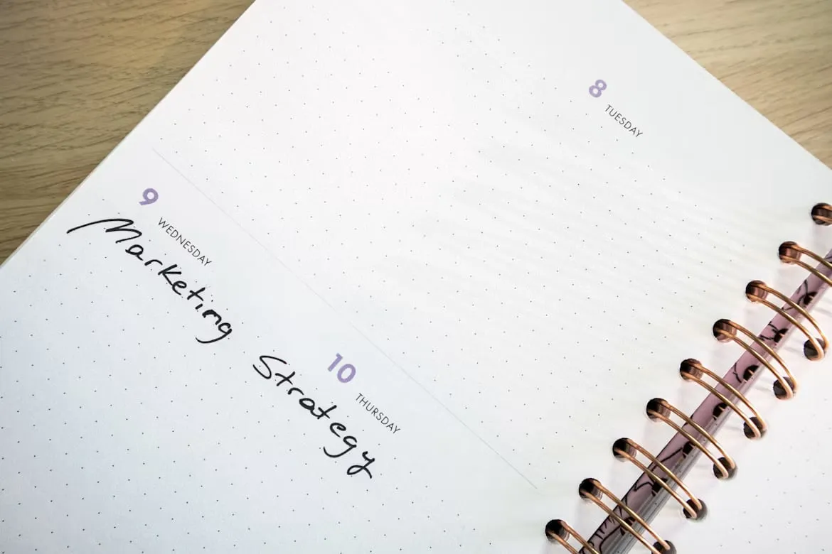 An open weekly planner with marketing strategy written across its pages.