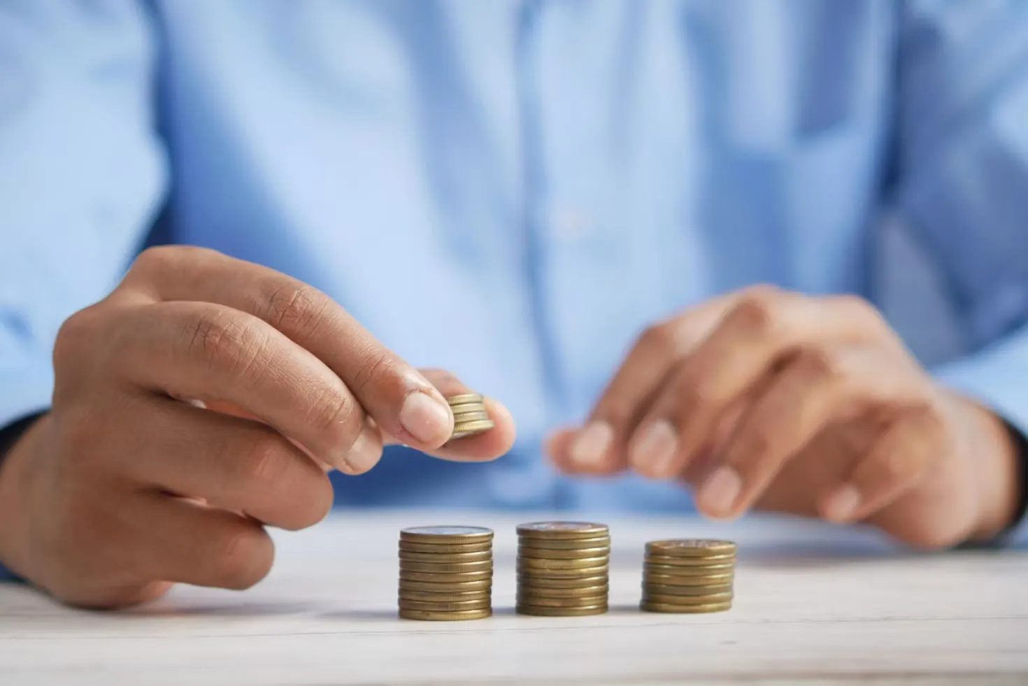 Person arranging stacks of coins at different levels
