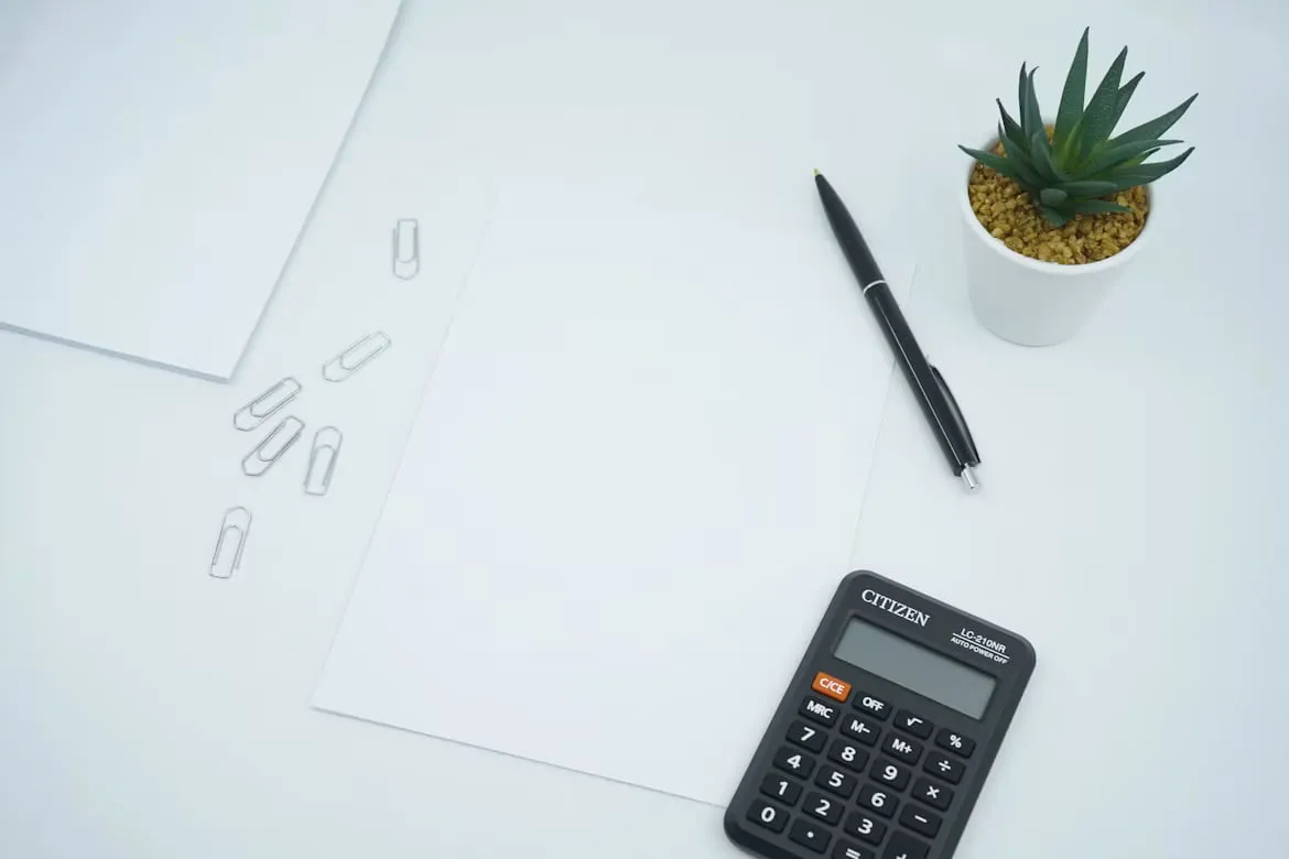 Calculator, pen and blank planning sheets on a desk