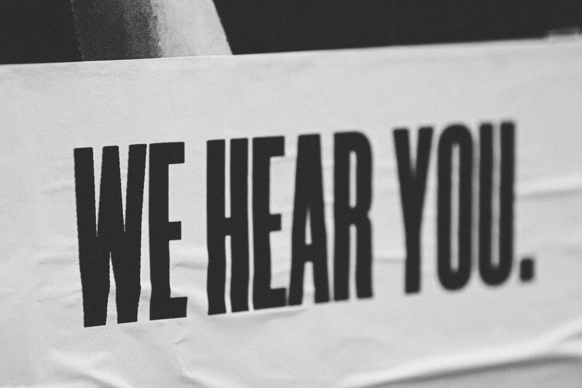 A photographed sign reading We hear you.