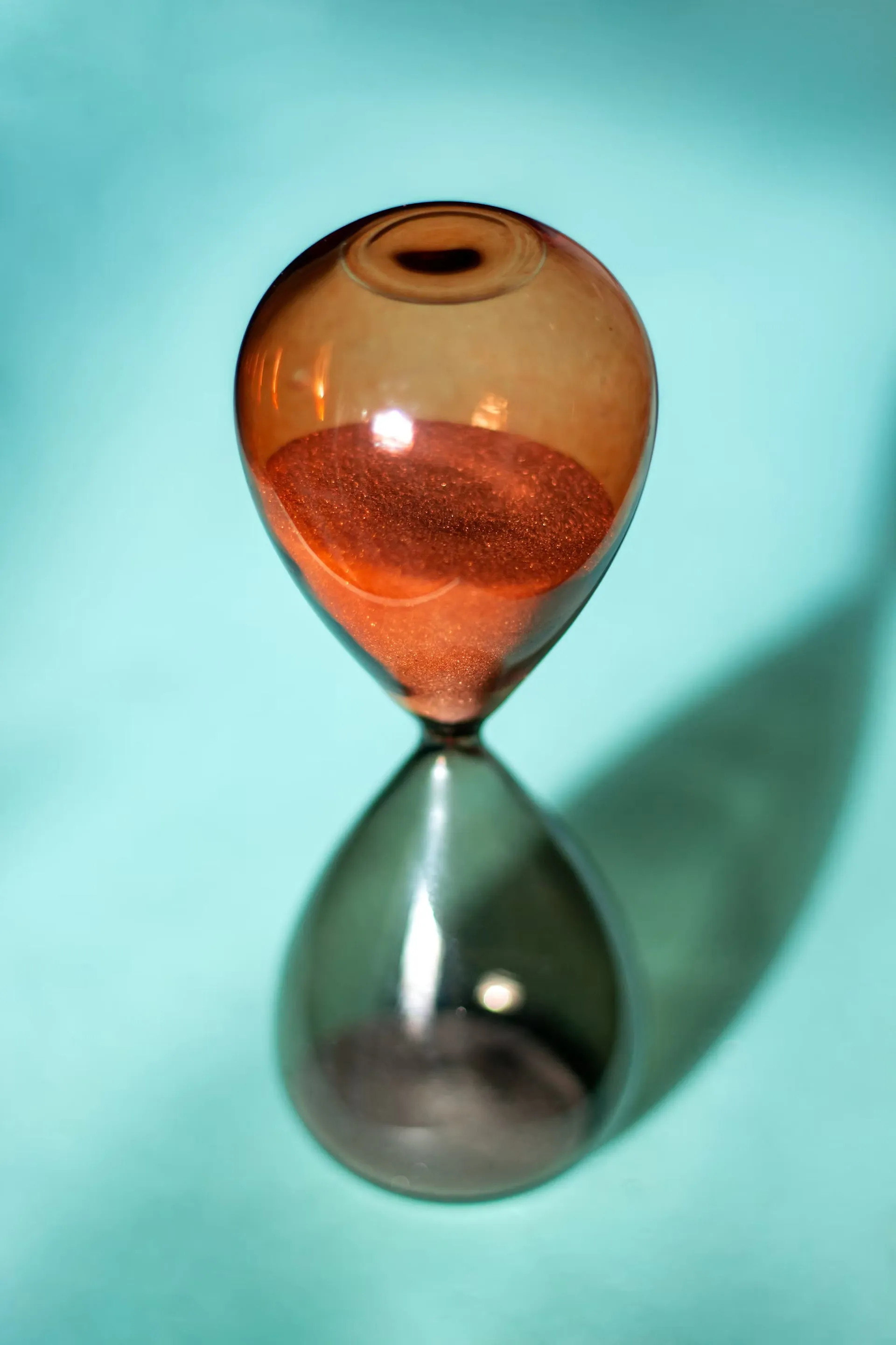 Sand runs through a glass hourglass, illustrating a reward that is still pending.
